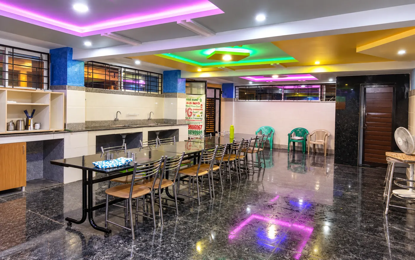 Dining area with a long table and colourful ceiling lights
