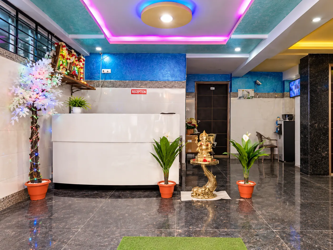 Reception with a white desk and colourful ceiling lights